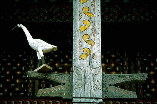 At a Toraja (Indigenous people of Sulawesi) house, abstract designs and a sculpture of a stork adorn the exterior