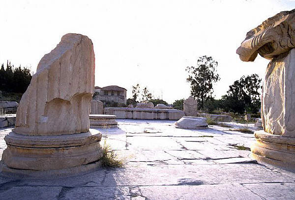 Fragmentary columns on a worn stone pavement flank the propylea, or entrance to the sacred area, at the ruins of Eleusis