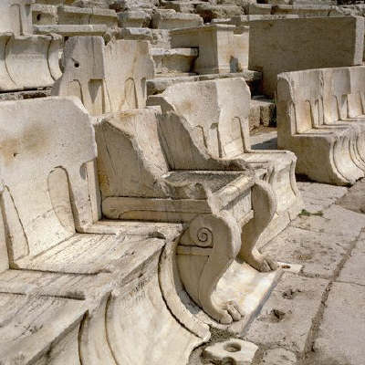 Tiers of seats climb the Roman ruins of an amphitheater in Athens