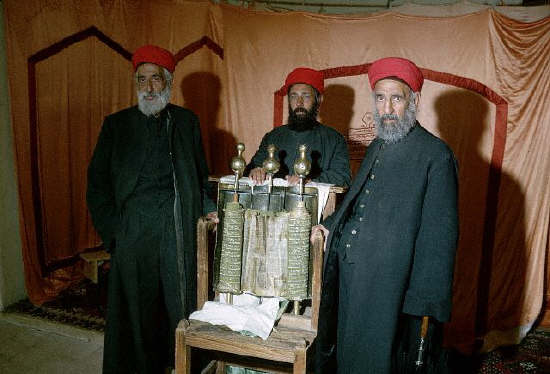 Three priests stand near a Torah, dating to the Middle Ages