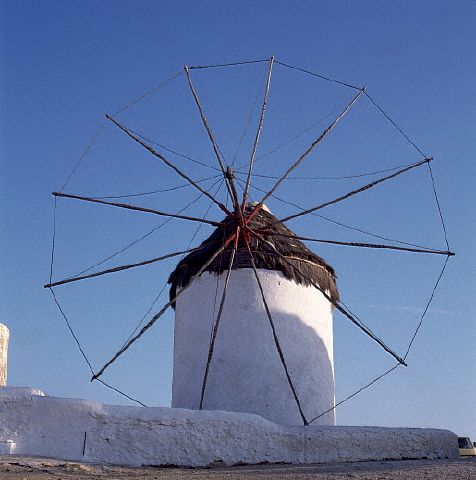 A simple windmill with a single, spoked sail stands at Mykonos, Greece