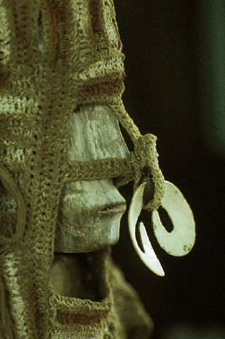 A statue of the Asmat Region of Irian Jaya, Indonesia, has a woven headdress and a symbolic nose-bone