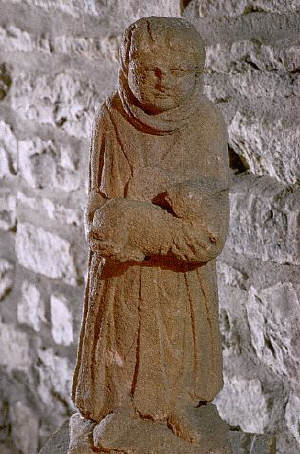 A Roman statuette depicts a pilgrim cradling a young animal