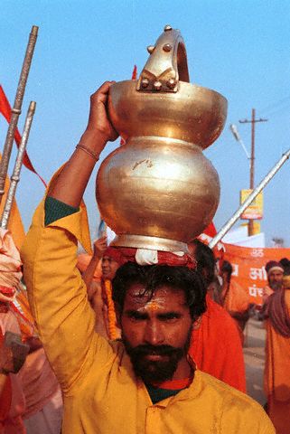 A man carries a jug (kumbh) containing holy water from the river