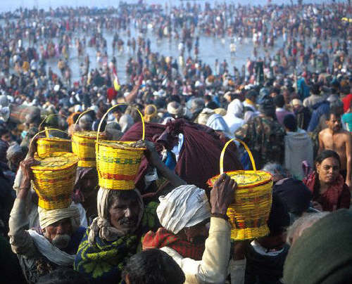 Men carrying water from the river in cane baskets, on the banks of the Ganges