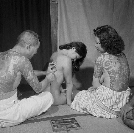 A Japanese tattoo artist works on the back of a woman 1946